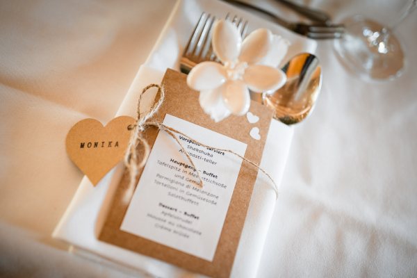 Hochzeitsgedeck mit Menükarte und Namensschild auf der Gutsalm Harlachberg