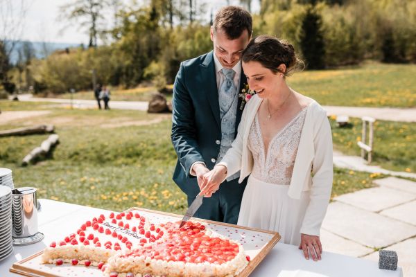 Bettina und Jonas schneiden die Hochzeitstorte auf der Gutsalm Harlachberg an
