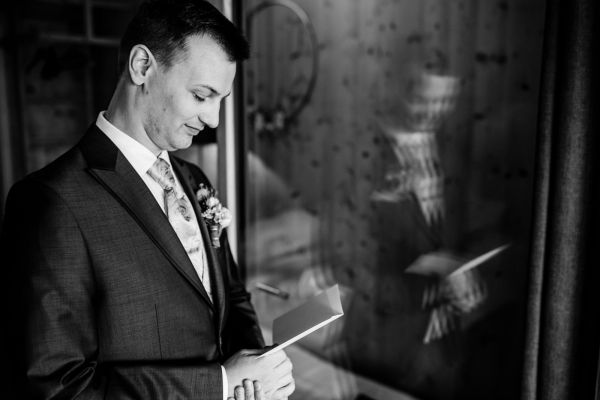 Bräutigam liest Brief vor der Trauung auf der Gutsalm Harlachberg