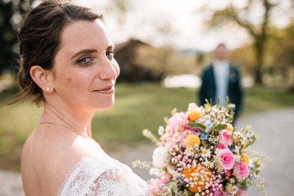 Braut mit Blumenstrauß bei der Hochzeit auf der Gutsalm Harlachberg