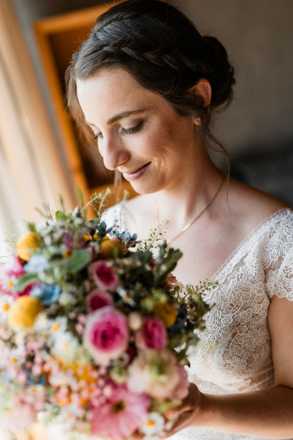 Braut mit Blumenstrauß bei der Hochzeit auf der Gutsalm Harlachberg