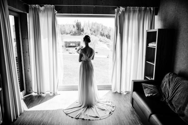 Braut vor dem Fenster auf der Gutsalm Harlachberg