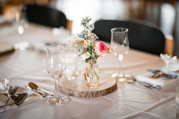 Festlich gedeckter Hochzeitstisch mit Blumendekoration auf der Gutsalm Harlachberg