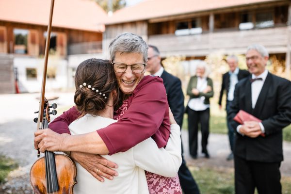 Herzliche Umarmung bei der Hochzeit von Bettina und Jonas auf der Gutsalm Harlachberg
