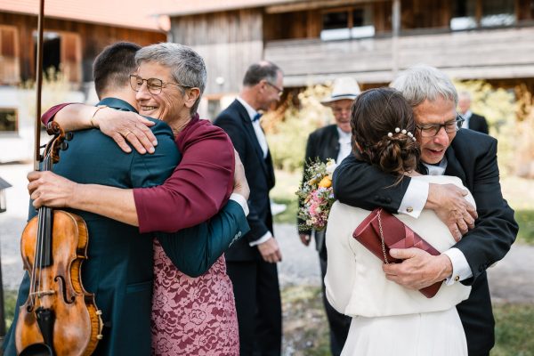 Herzliche Umarmungen bei der Hochzeit von Bettina und Jonas auf der Gutsalm Harlachberg