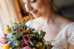 Braut mit Blumenstrauß bei der Hochzeit auf der Gutsalm Harlachberg