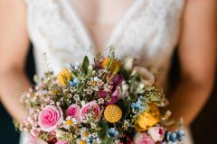 Braut mit buntem Brautstrauß bei der Hochzeit auf der Gutsalm Harlachberg