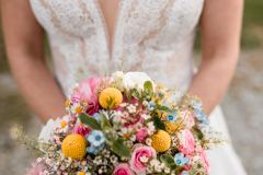 Braut mit farbenfrohem Brautstrauß bei der Hochzeit auf der Gutsalm Harlachberg