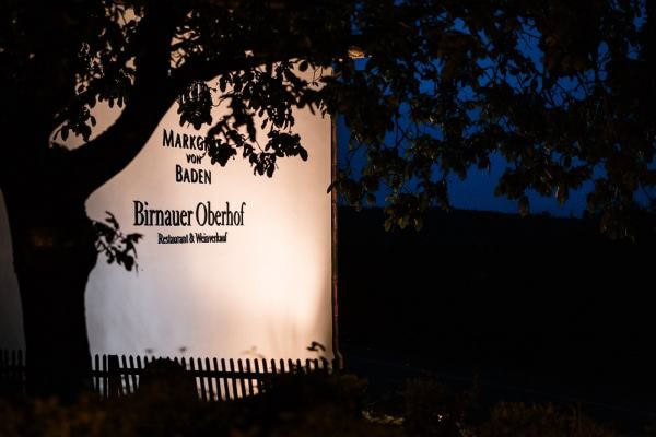 Beleuchtetes Schild des Birnauer Oberhofs bei Nacht