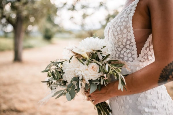 Braut mit Hochzeitsstrauß im Freien