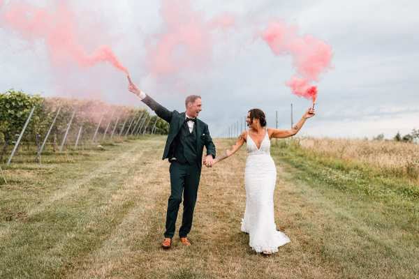 Hochzeitspaar mit Rauchfackeln im Weinberg am Bodensee