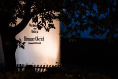 Beleuchtetes Schild des Birnauer Oberhofs bei Nacht
