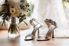 Elegante Hochzeitschuhe und Blumen beim Getting-Ready